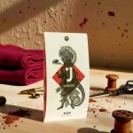 Bílá čokoláda Jordis 40% s kousky kakaových bobů POP Naturally. Detailní záběr na obal produktu s ilustrací.