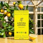 Balení tmavé organické čokolády Cacao Crudo s citronovou kůrou na žlutém pozadí.
