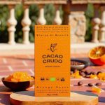 Balení tmavé organické čokolády Cacao Crudo s pomerančovou kůrou a kakaovými boby.