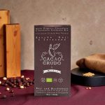 Tmavá organická čokoláda s goji a pohankou v elegantním obalu na tmavém pozadí.